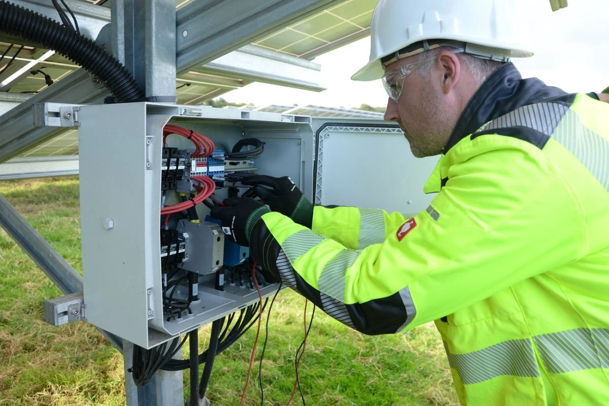 Técnico inspecionando quadro elétrico de usina solar