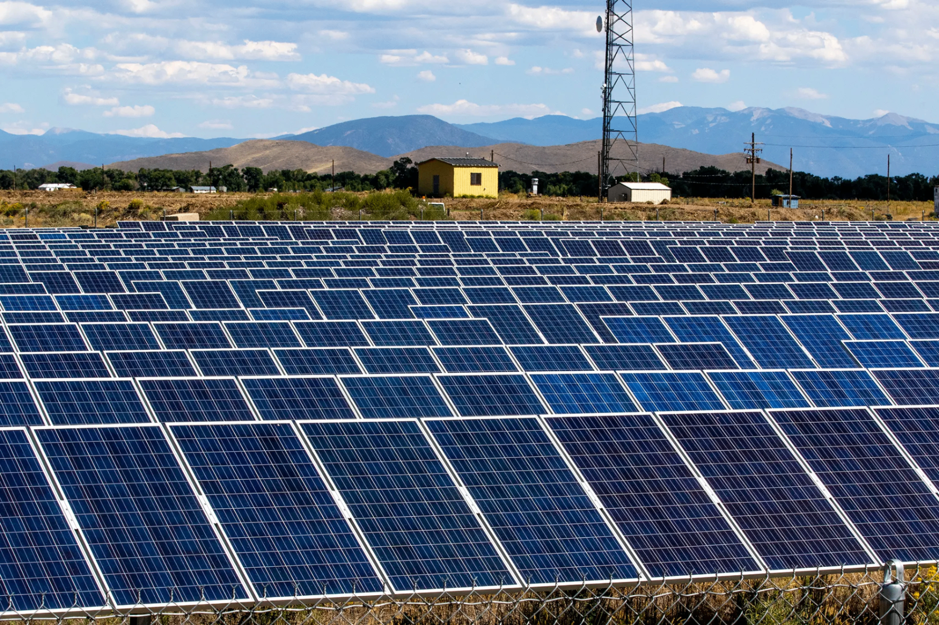 Usina solar com paisagem de montanhas ao fundo